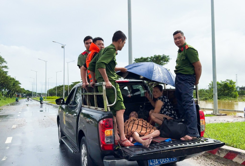 Lực lượng Công an phường Ngũ Hành Sơn hỗ trợ đưa người dân vùng ngập khu vực Mân Quang đến nơi an toàn. (Ảnh: danang.gov.vn)