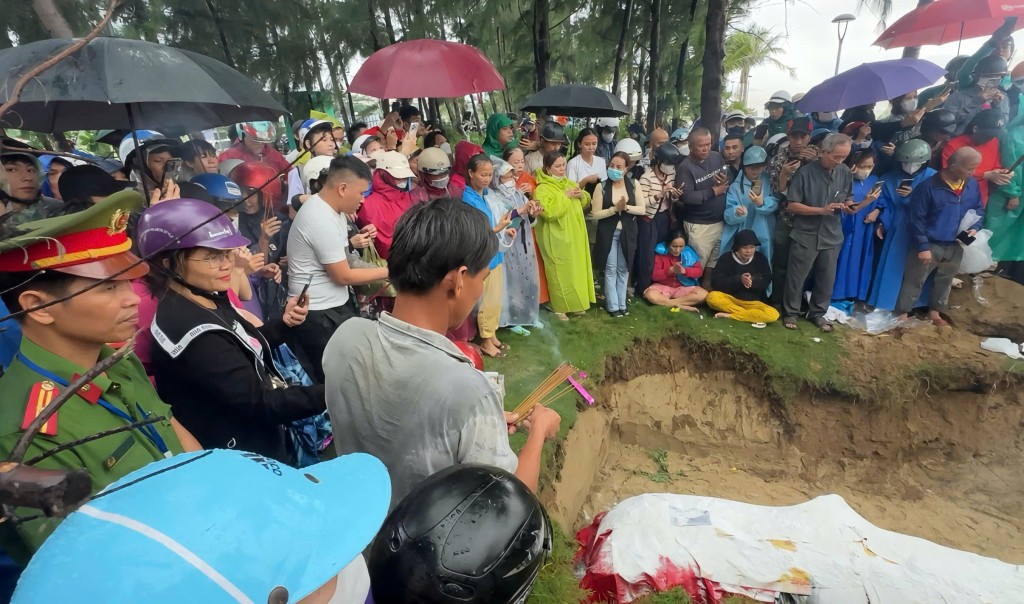 Người dân Đà Nẵng đội mưa làm lễ an táng cá Ông trôi dạt vào bờ theo nghi thức truyền thống.