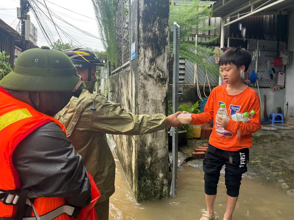 Đồng thời chuẩn bị cháo nóng và nước uống cho các hộ ngập sâu (Ảnh Đ.Minh)