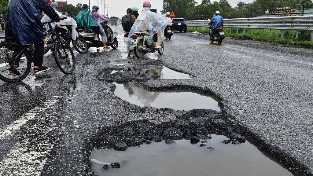 Km 851+300 nhiều ổ voi lớn (gần trường trung học phổ thông An Lương Đông) các em học sinh qua lại nhiều, tiềm ẩn nguy cơ tai nạn giao thông (Ảnh: H.Quảng