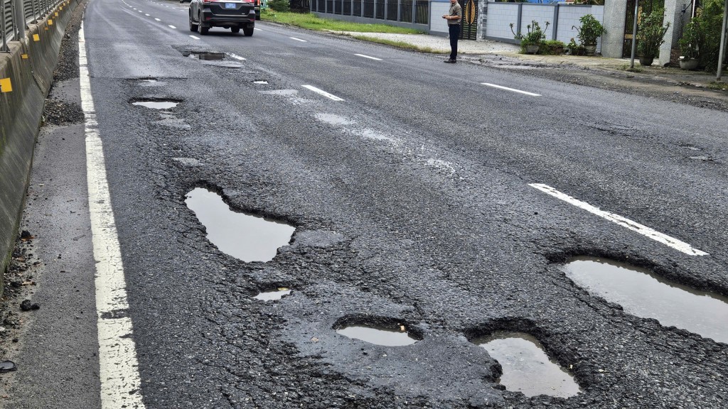 Mỗi khi mưa xuống, nước đọng trong các vết nứt, làm hư hại lớp mặt đường vốn đã yếu, khiến ổ gà tái xuất hiện với mật độ dày đặc hơn (Ảnh H.Quảng)