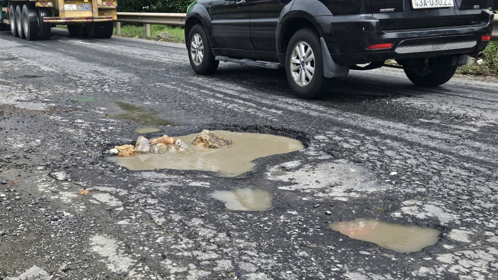 Khi trời mưa, số đá này bị nước xói trôi, để lại mặt đường gồ ghề, trơn trượt, khiến nguy cơ tai nạn tăng cao (Ảnh H.Quảng)