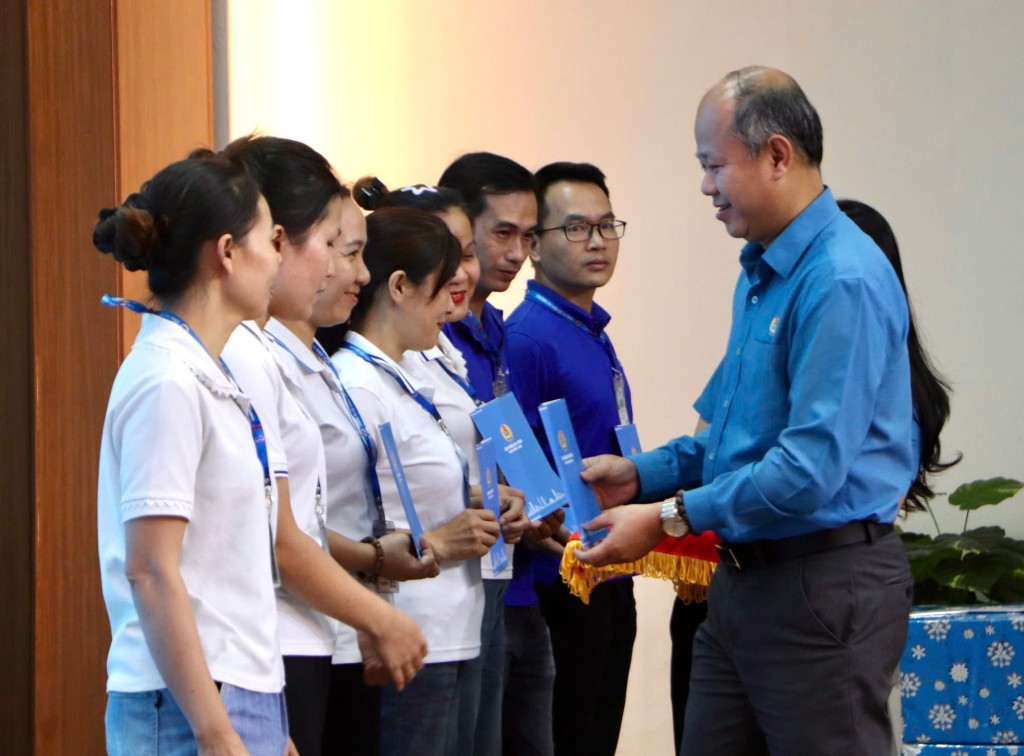 Ông Lê Văn Đại, Phó Chủ tịch Thường trực Liên đoàn Lao động thành phố Đà Nẵng, trao hỗ trợ cho công nhân chịu thiệt hại do bão lũ (Ảnh Út Vũ)