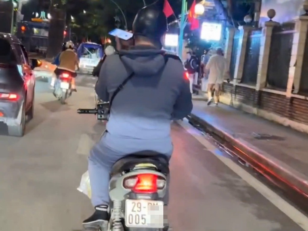 Hình ảnh nam thanh niên sử dụng điện thoại di động khi đang điều khiển xe máy được người dân ghi lại