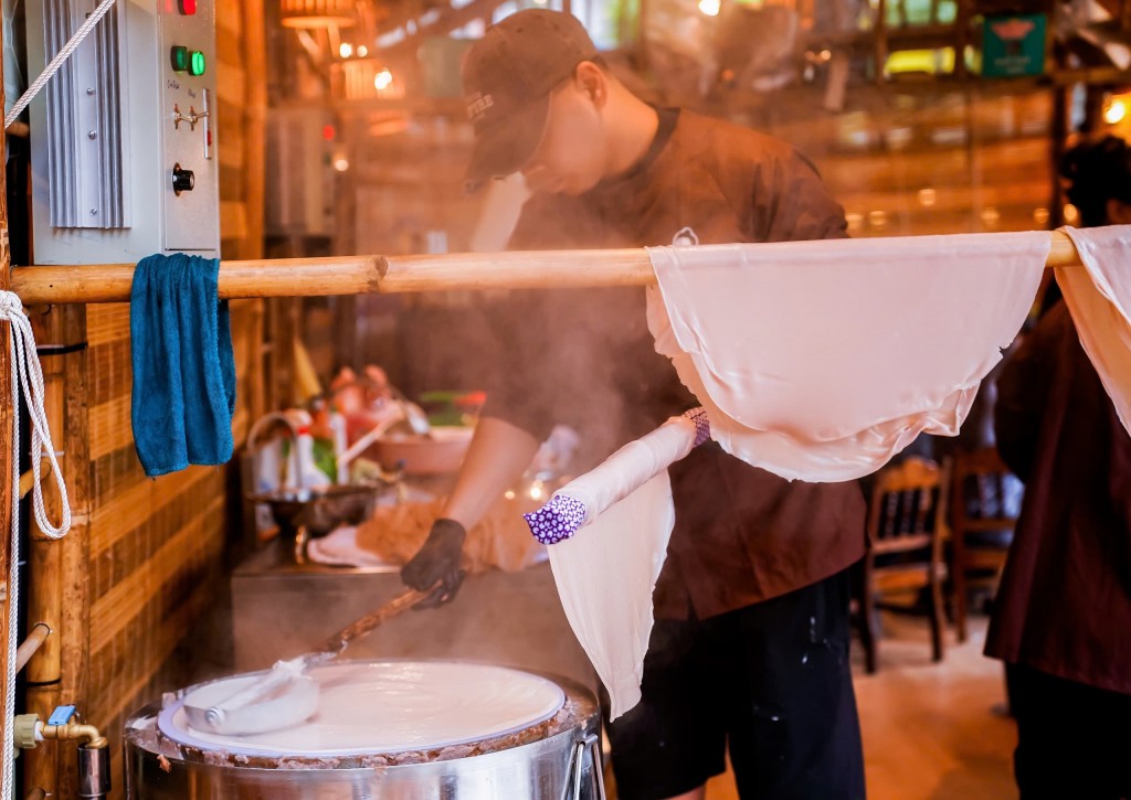 Công đoạn tráng bánh phở thủ công với lớp bánh vừa vớt lên còn nghi ngút hơi nước Công đoạn tráng bánh phở thủ công với lớp bánh vừa vớt lên còn nghi ngút hơi nước