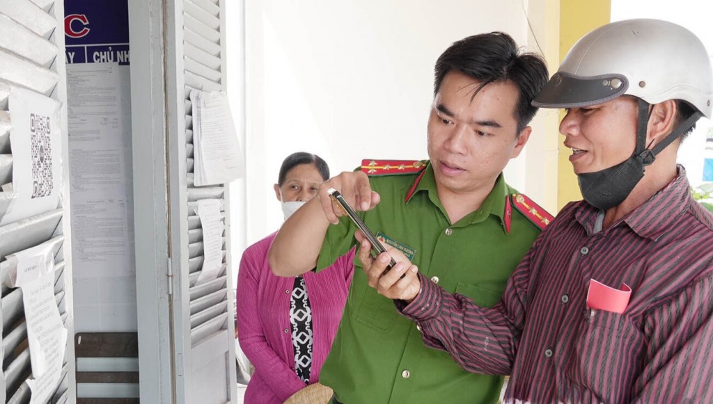 Cán bộ Công an xã hướng dẫn người dân quét mã QR để truy cập thông tin phòng, chống tội phạm trên Zalo.