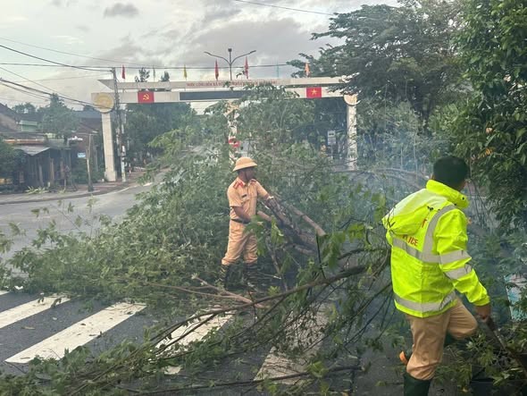 Chiến sĩ Cảnh sát giao thông cắt dọn cây gãy đổ, khôi phục lại làn xe bị phong tỏa. Ảnh: C.A Quảng Ngãi) Chiến sĩ Cảnh sát giao thông cắt dọn cây gãy đổ, khôi phục lại làn xe bị phong tỏa. Ảnh: C.A Quảng Ngãi)