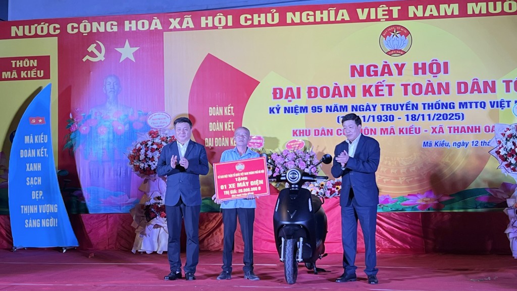 Phó Chủ tịch Thường trực UBND TP Dương Đức Tuấn và Bí thư Đảng ủy xã Thanh Oai Bùi Hoàng Phan trao tặng xe máy điện cho hộ gia đình khó khăn.