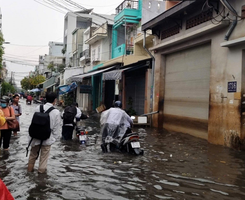 Người dân phải dắt xe vì triều cường Người dân phải dắt xe vì triều cường