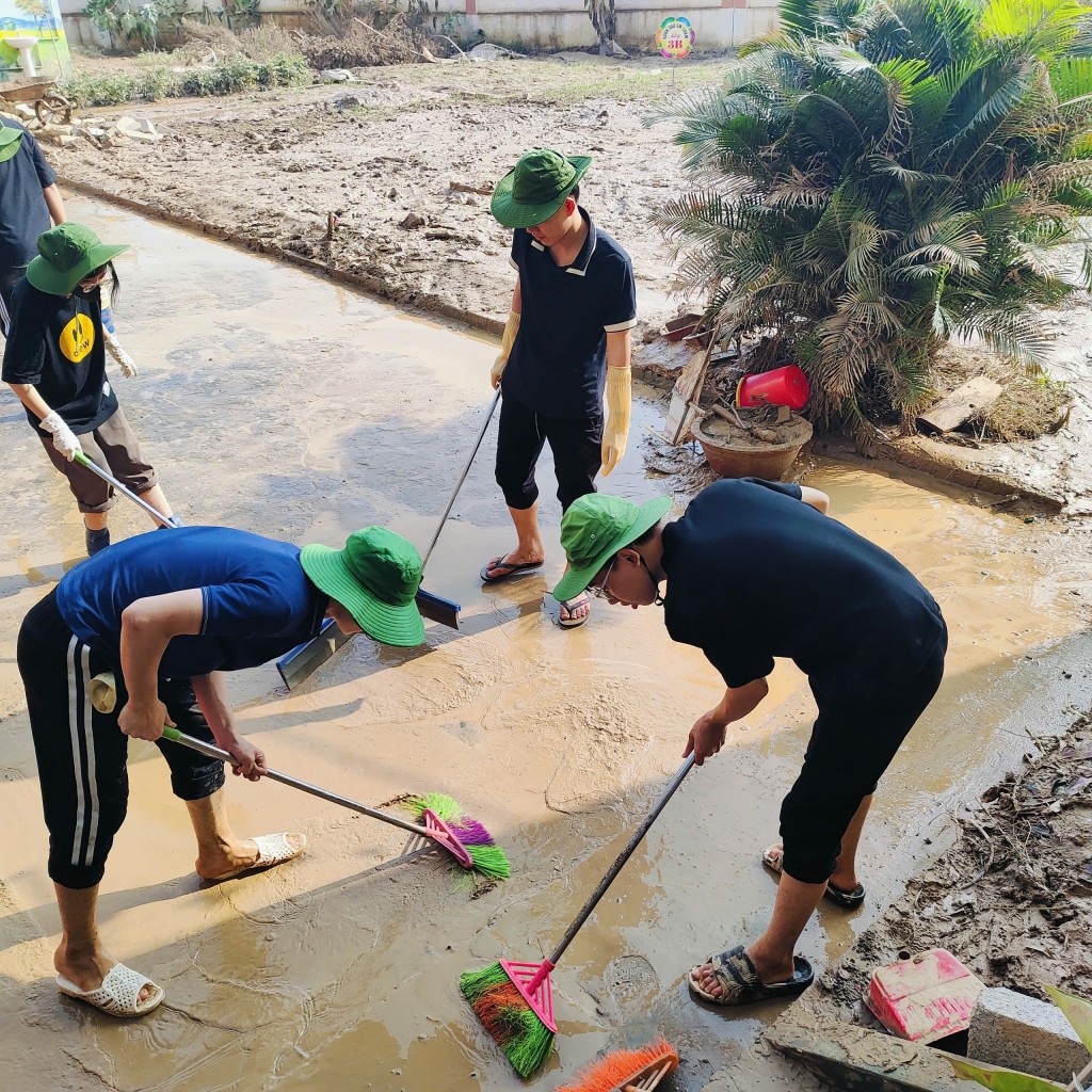 Đoàn viên thanh niên tham gia dọn dẹp bùn đất, hỗ trợ khắc phục hậu quả thiên tai cùng người dân địa phương.