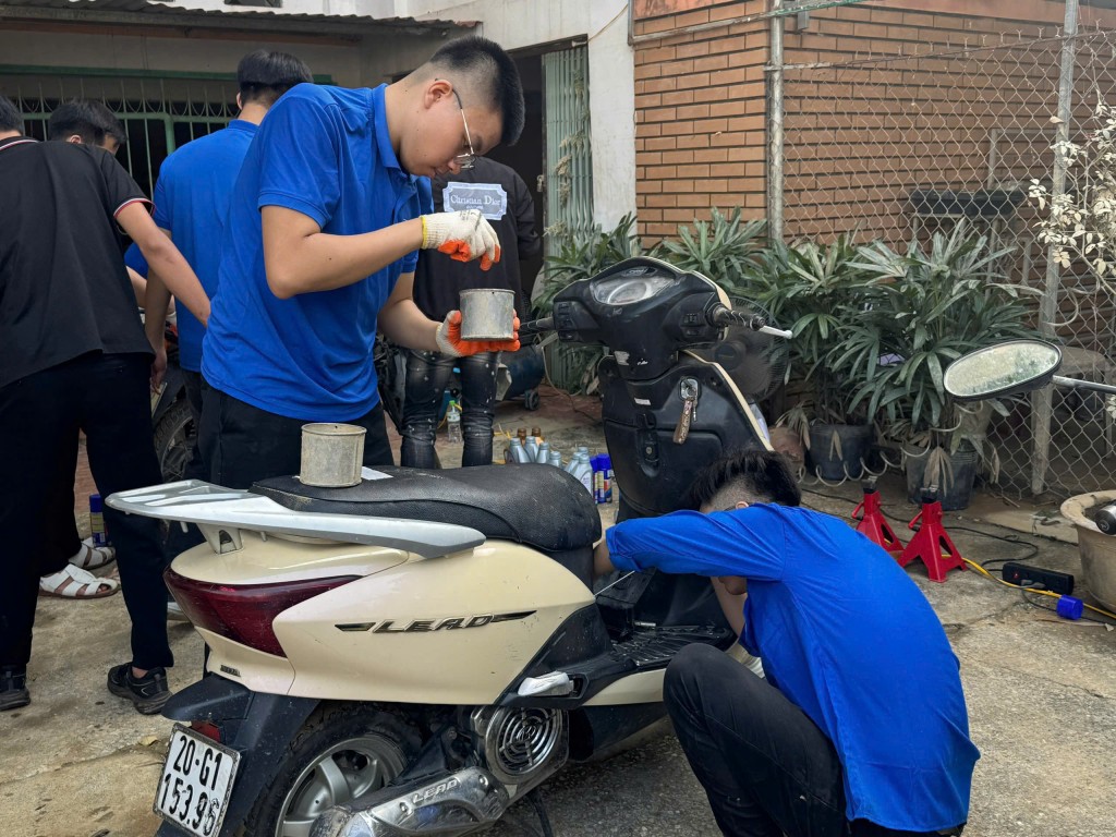 Đoàn viên thanh niên hỗ trợ người dân sửa chữa, bảo dưỡng xe máy sau mưa lũ.