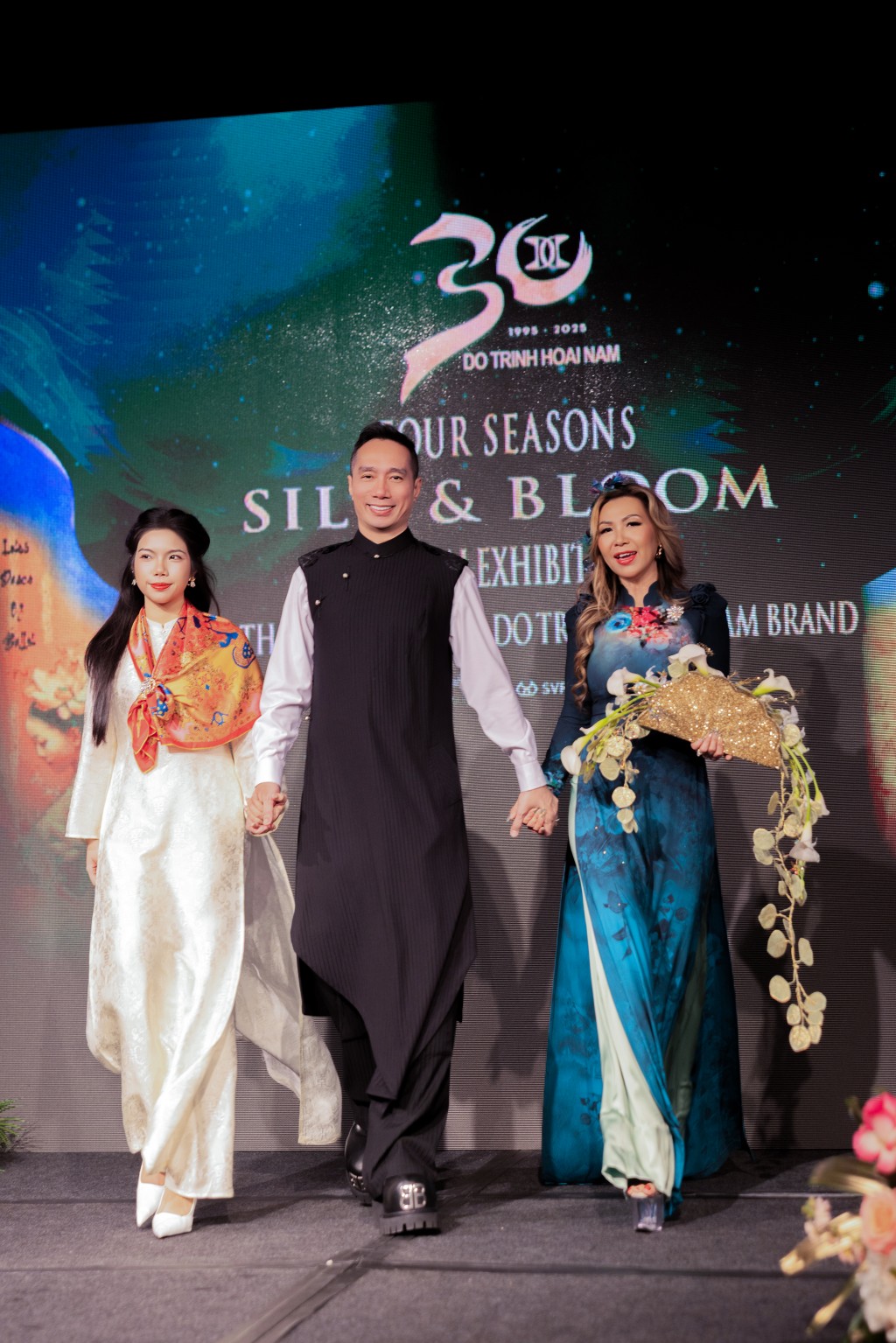 Khoảnh khắc đầy cảm xúc của đêm diễn khi NTK Đỗ Trịnh Hoài Nam, nghệ nhân hoa Minnie Uyên Thái ( phải), đạo diễn Đỗ Bảo Ngọc (trái) bước ra sân khấu trong tiếng vỗ tay nồng nhiệt của khách mời và khán giả