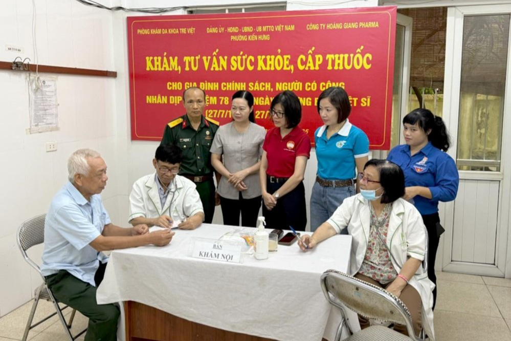 : Chủ tịch Ủy ban MTTQ Việt Nam phường Kiến Hưng (Hà Nội) Hoàng Thị Huyền Trang (ở giữa, hàng 2) thăm hỏi động viên người dân trong chương trình khám bệnh, phát thuốc miễn phí