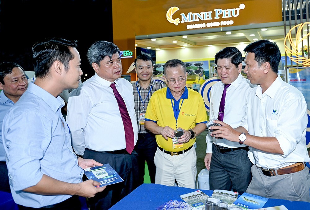 Trần Thanh Nam, Thứ trưởng Bộ Nông nghiệp và Môi trường (thứ hai từ trái sang) và ông Lê Văn Sử, Phó Chủ tịch UBND tỉnh Cà Mau (thứ hai từ phải sang) tìm hiểu sản phẩm được trưng bày, giới thiệu tại Ngày hội Cua.