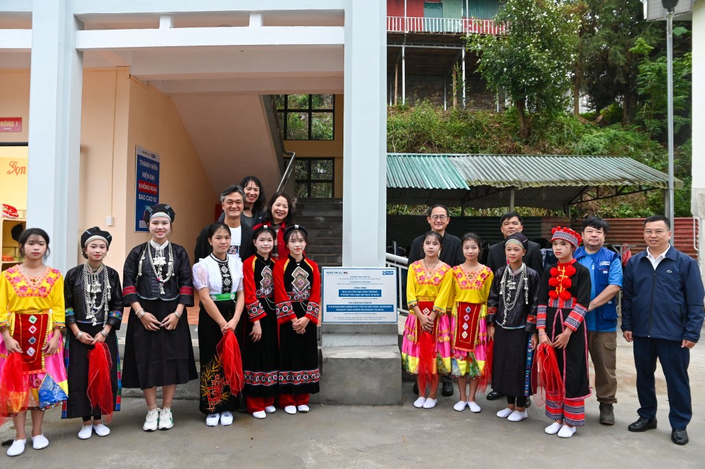 Các đại biểu cùng các em học sinh đứng trước khu nhà bán trú mới