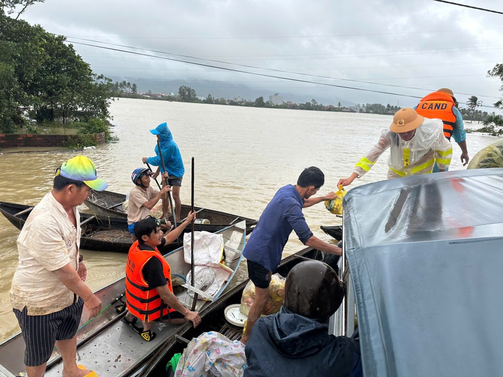 Trước biển nước mênh mông, người dân bơi xuồng nhận nhu yếu phẩm