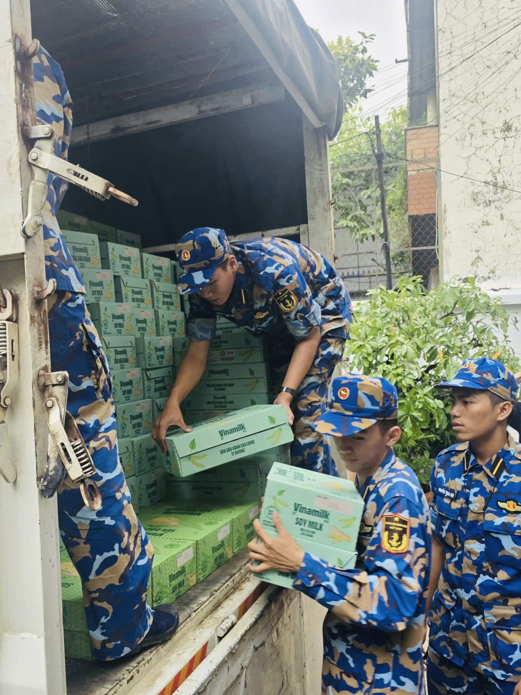 Các chiến sĩ Trung tâm Huấn luyện Vùng 4 Hải quân đang chuyền nhau các sản phẩm dinh dưỡng Vinamilk, sẵn sàng vận chuyển đến tận tay bà con vùng lũ - Ảnh: Vi Nam