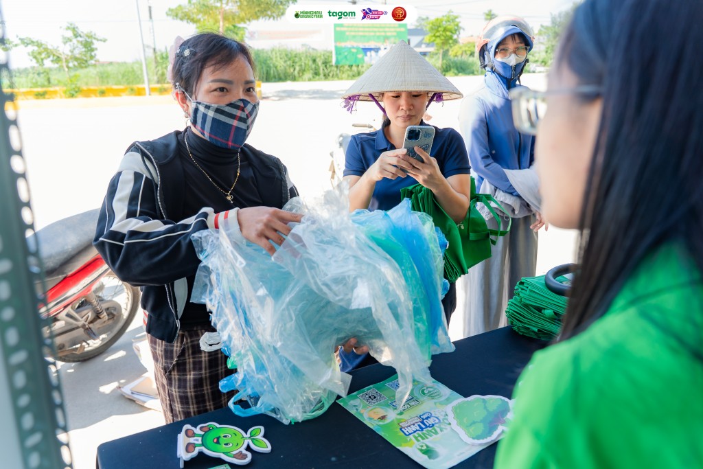 Người dân mang túi ni-lông đã qua sử dụng đến đổi lấy túi vải thân thiện môi trường, hưởng ứng mô hình “Biến rác thành tài nguyên”.