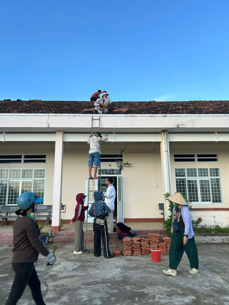  Giáo viên và phụ huynh Trường Tiểu học số 1 Cát Trinh cùng chung sức lợp lại mái ngói bị tốc sau bão, nỗ lực khắc phục thiệt hại để sớm đưa học sinh trở lại lớp.