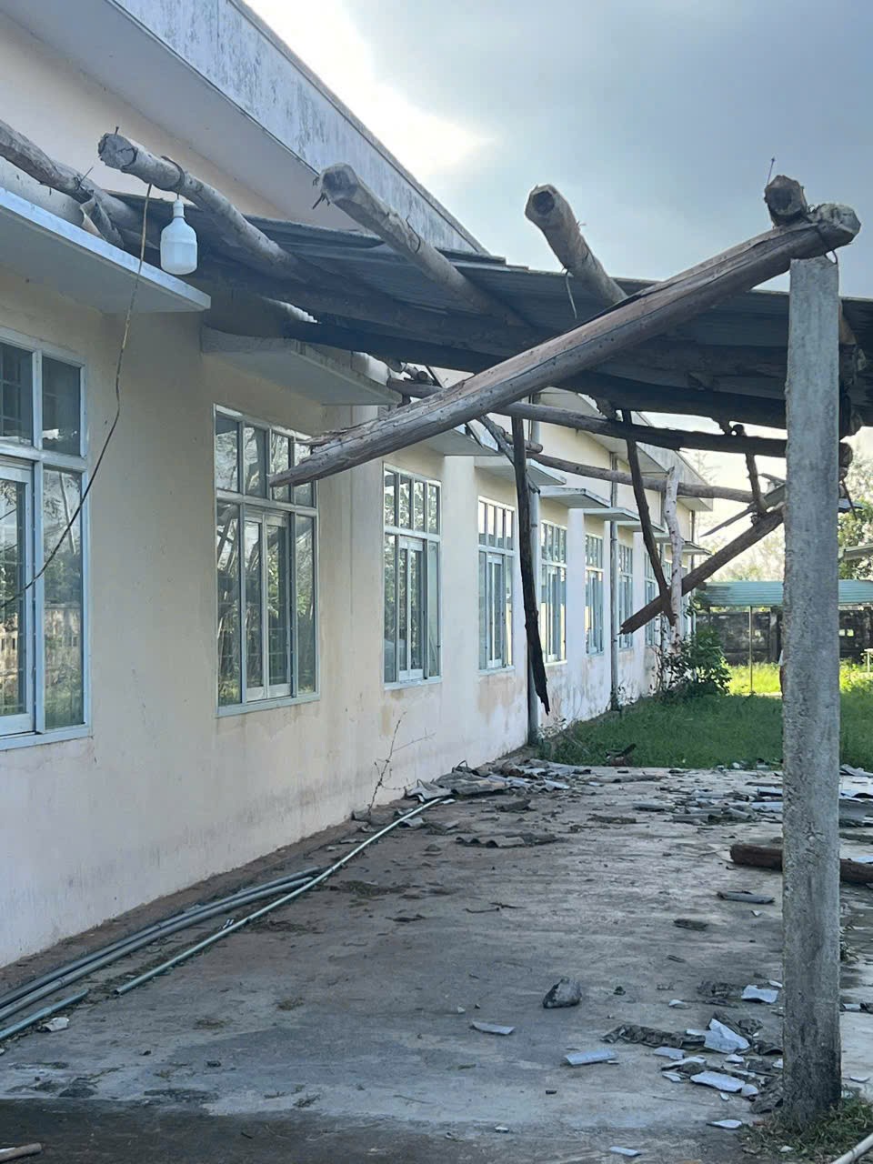 Khu vực hành lang và mái che bị hư hỏng, ngổn ngang vật liệu gãy đổ – cảnh tượng còn lại tại trường sau trận gió bão khiến nhiều phòng học thấm dột và mất an toàn
