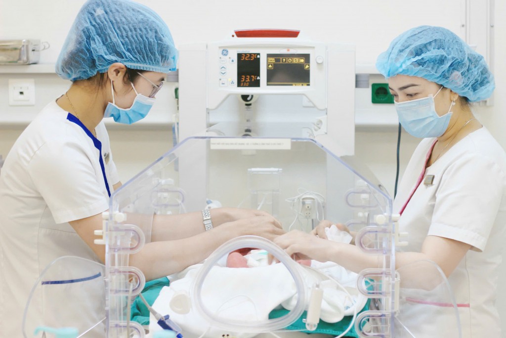 Bé trai được chăm sóc, theo dõi trong lồng ấp áp lực dương Bé trai được chăm sóc, theo dõi trong lồng ấp áp lực dương