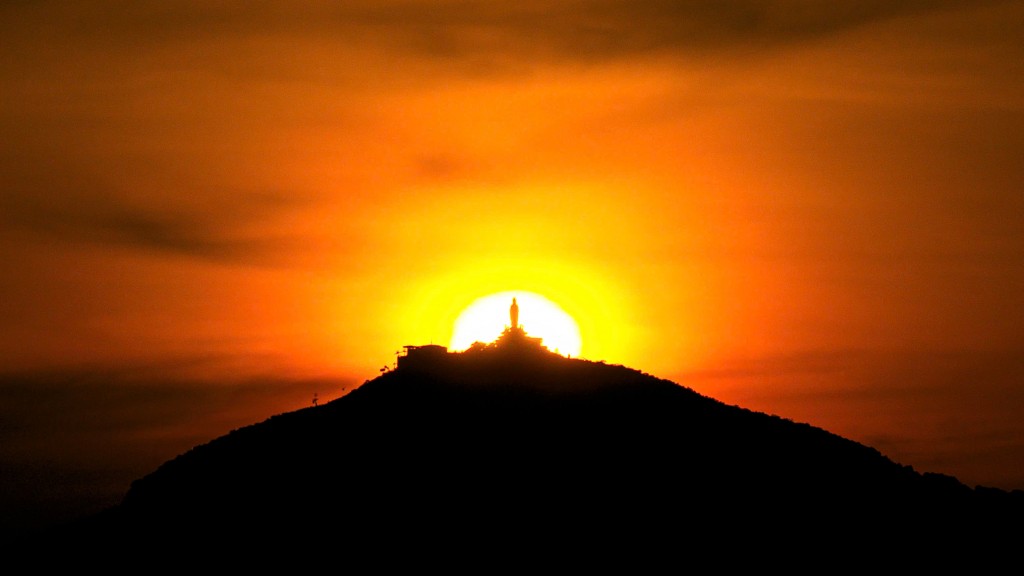Ánh hoàng hôn lặn sau lưng tượng Phật Bà Tây Bổ Đà Sơn trên đỉnh núi. Ảnh: Hải Triều