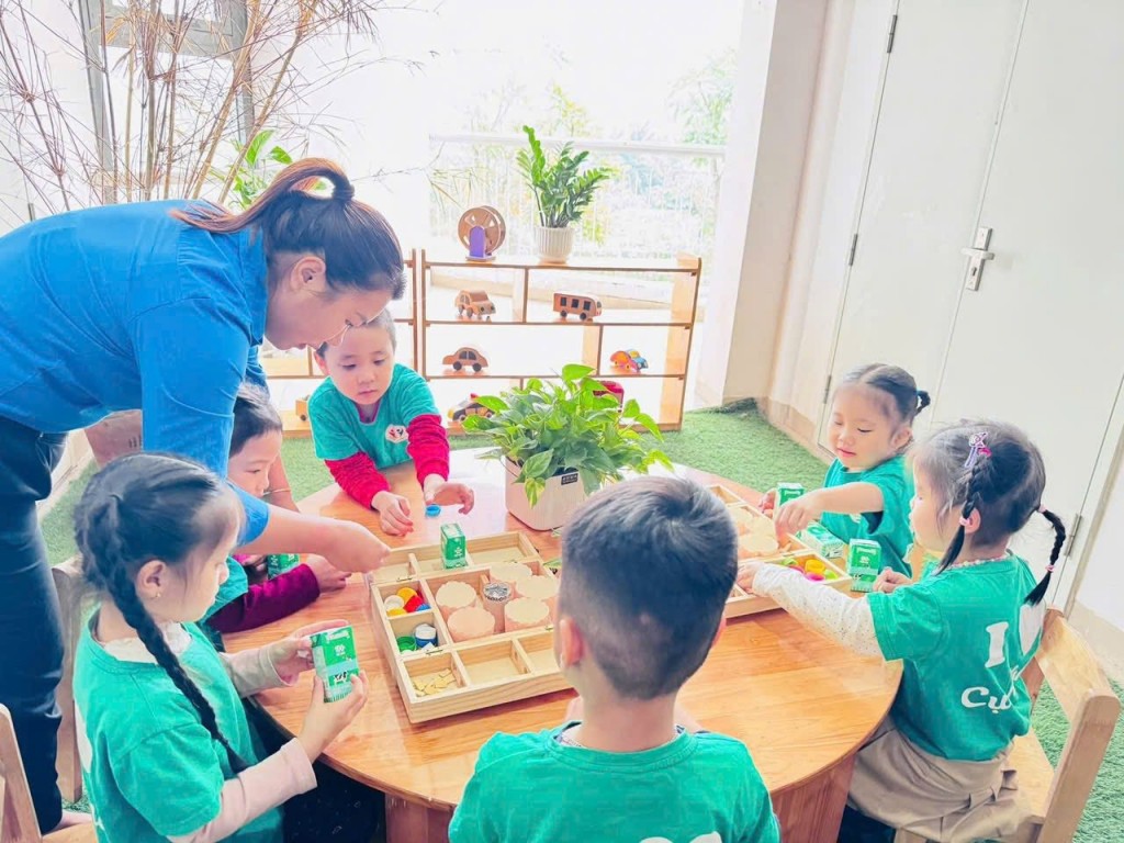 Giáo viên hướng dẫn trẻ trải nghiệm các học liệu trực quan trong không gian số của nhà trường.