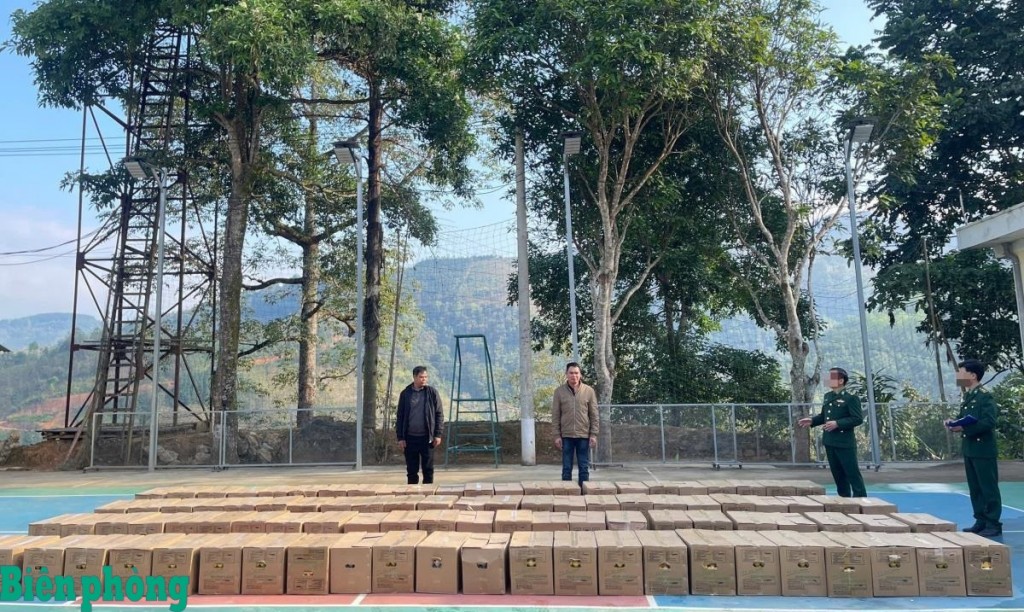 Các đối tượng Lục Văn Dào (áo khoác đen bên trái) và Nông Văn Khón cùng tang vật bị bắt giữ tại Đồn Biên phòng Cốc Pàng. Ảnh: Huy Dương