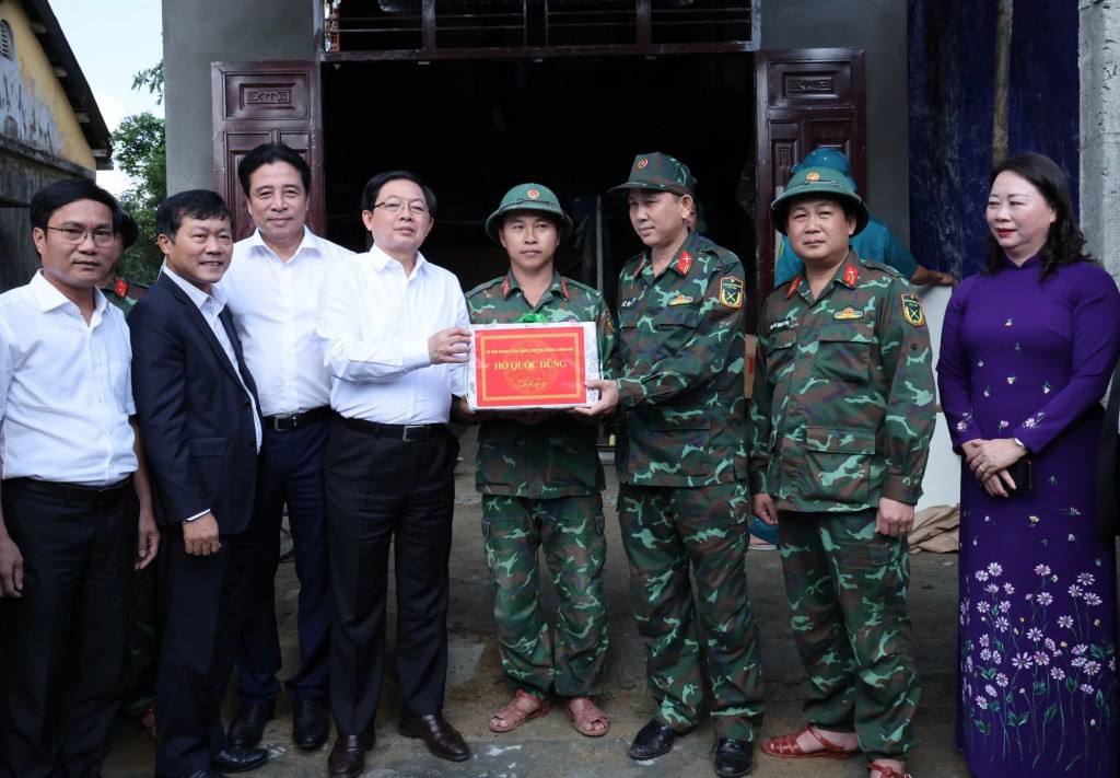 Phó Thủ tướng Hồ Quốc Dũng động viên, tặng quà lực lượng vũ trang đang xây dựng nhà cho gia đình ông Nguyễn Văn Đức (thôn Đồng Xuân) - Ảnh: VGP/Gia Huy