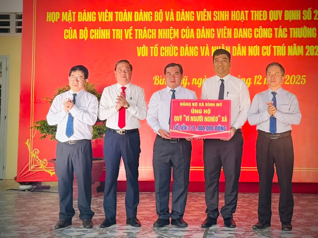Lãnh đạo xã Bình Mỹ trao bảng tượng trưng ủng hộ Quỹ “Vì người nghèo” với số tiền 136 triệu đồng.