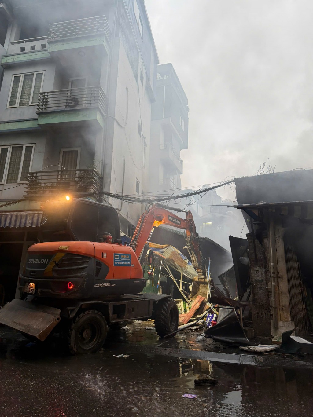 Cảnh sát PCCC và CNCH huy động máy xúc mở đường dập lửa, ngăn chặn cháy lan sang các nhà dân xung quanh