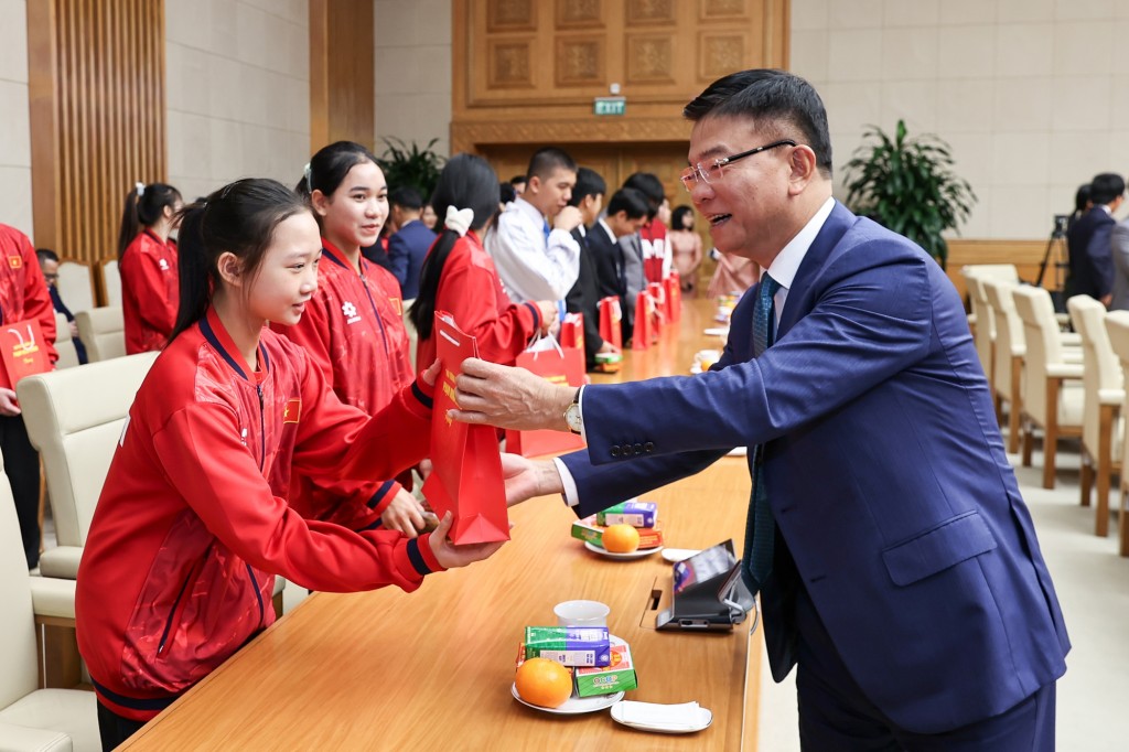 Phó Thủ tướng Chính phủ Lê Thành Long tặng quà các em học sinh đoạt giải tại các kỳ thi quốc tế năm 2025 - Ảnh: VGP/Nhật Bắc