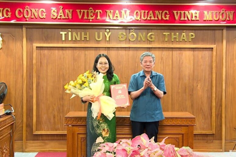 Đồng chí Ngô Chí Cường, Ủy viên Ban Chấp hành Trung ương Đảng, Bí thư Tỉnh ủy (bên phải) trao Quyết định, tặng hoa chúc mừng đồng chí Nguyễn Thị Lan.