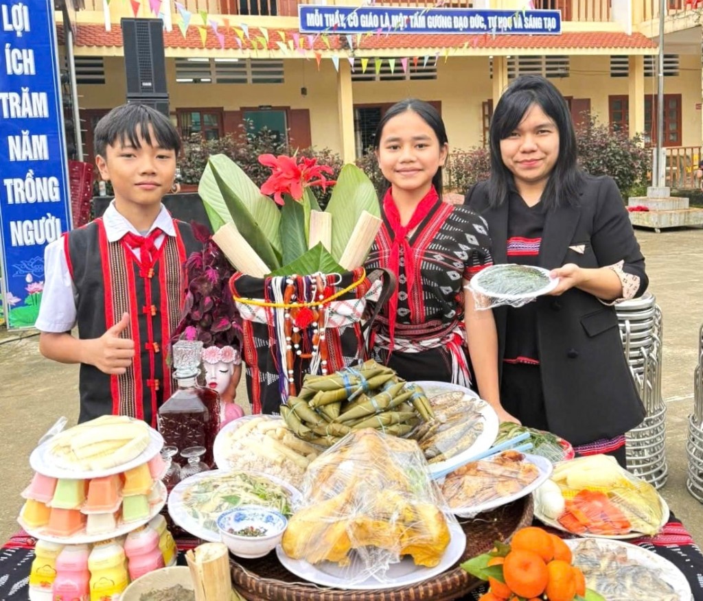 Học sinh trường Phổ thông dân tộc nội trú - THCS xã Đông Giang bên mâm lễ dâng lên thần linh trong lễ hội Mừng lúa mới