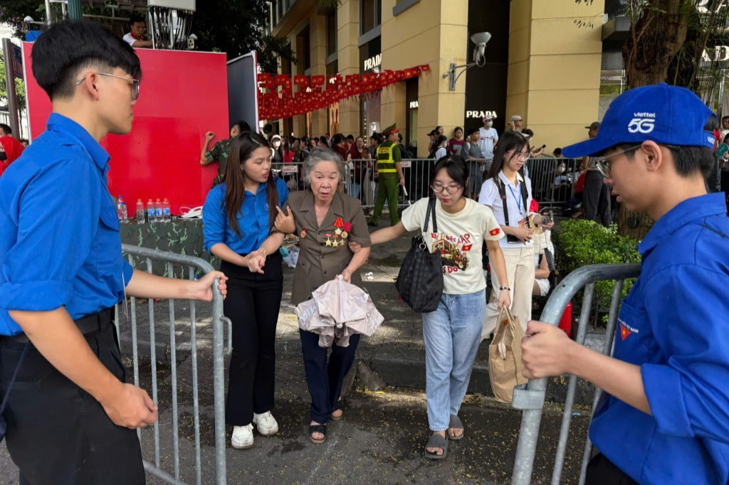 Thanh niên tình nguyện hỗ trợ người dân về tham dự các hoạt động trong Đại lễ A80