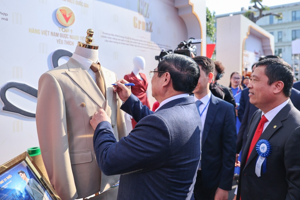 Thủ tướng ký lưu bút lên sản phẩm sản xuất thứ 25 triệu của Tổng công ty May 10 - Ảnh: VGP/Nhật Bắc Thủ tướng ký lưu bút lên sản phẩm sản xuất thứ 25 triệu của Tổng công ty May 10 - Ảnh: VGP/Nhật Bắc