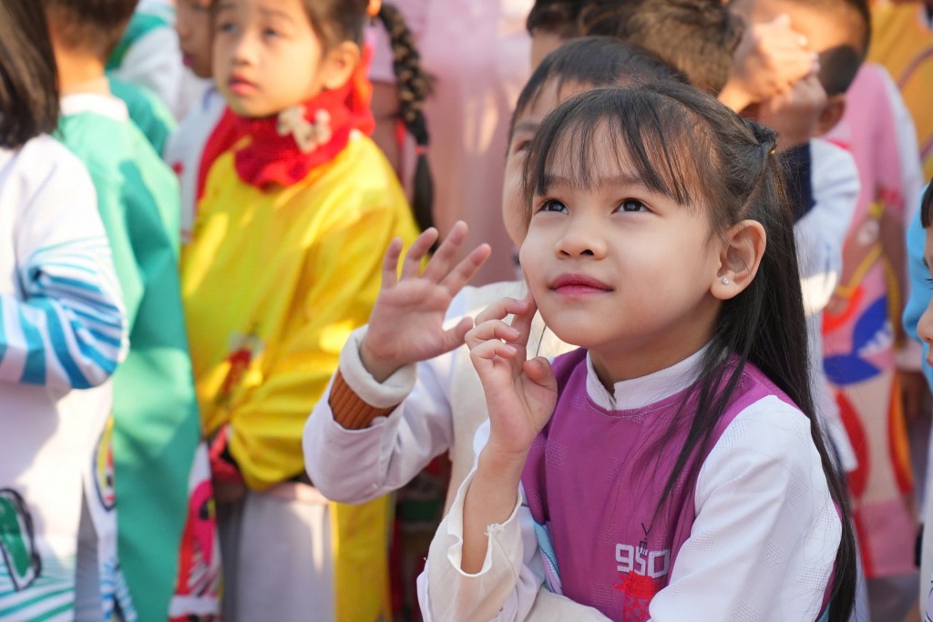 Nụ cười rạng rỡ và ánh mắt háo hức của học sinh tiểu học trong trang phục áo dài truyền thống, hòa mình vào không gian di sản nghìn năm. Nụ cười rạng rỡ và ánh mắt háo hức của học sinh tiểu học trong trang phục áo dài truyền thống, hòa mình vào không gian di sản nghìn năm.