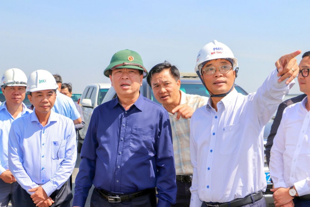 Ban Quản lý dự án Mỹ Thuận báo cáo tiến độ thi công với Bộ trưởng Bộ Xây dựng Trần Hồng Minh tại hiện trường dự án. Ban Quản lý dự án Mỹ Thuận báo cáo tiến độ thi công với Bộ trưởng Bộ Xây dựng Trần Hồng Minh tại hiện trường dự án.