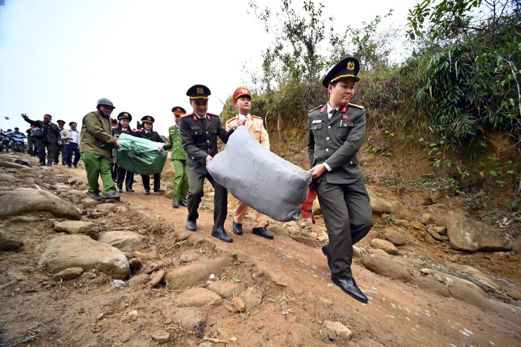 Đoàn viên thanh niên Công an TP Hà Nội và EVNNPC bê vác các nhu yếu phẩm lên các điểm trường trên vùng cao xã Trạm Tấu