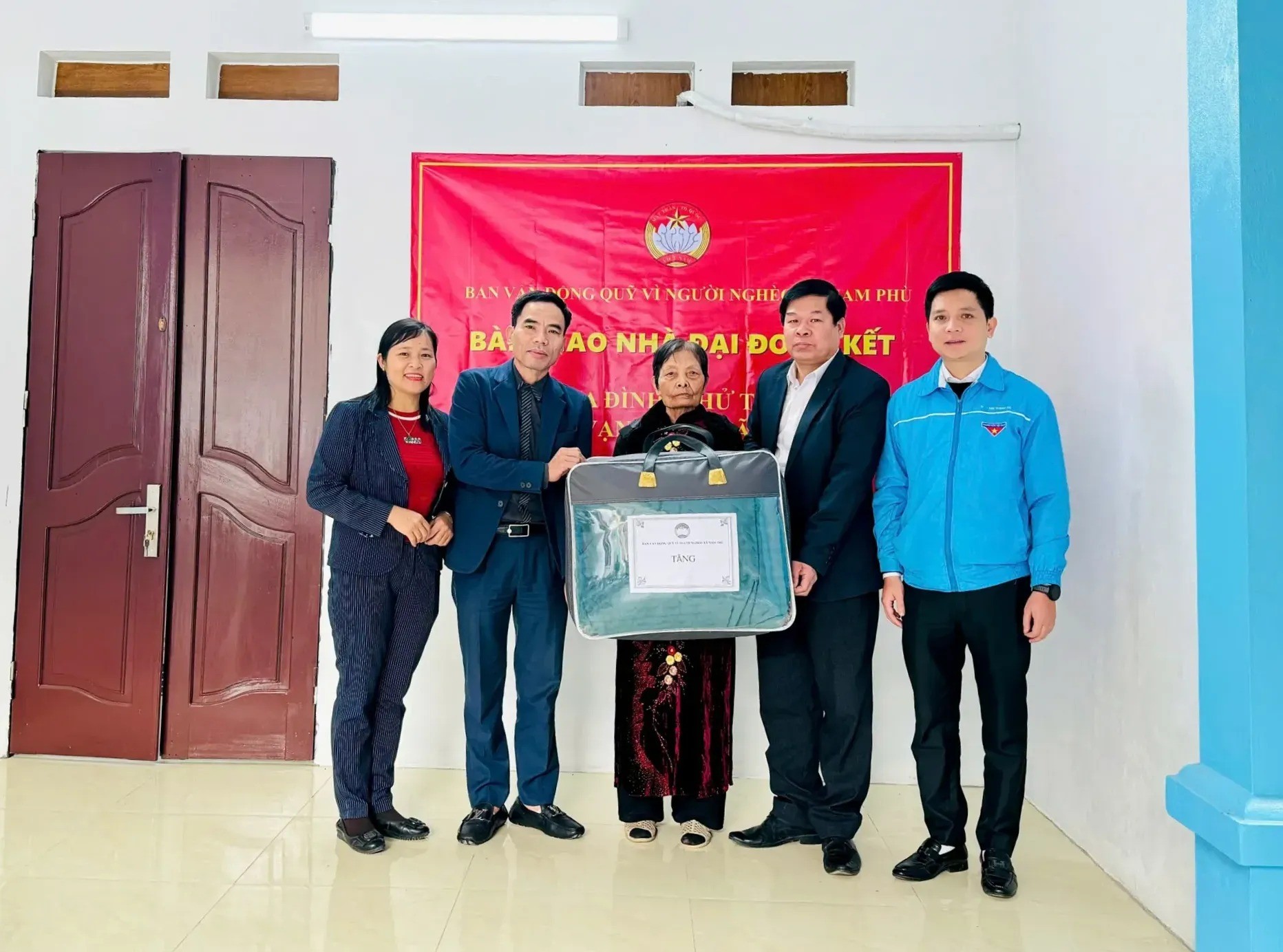 Đại diện các ban, ngành, đoàn thể tặng đồ dùng sinh hoạt cho gia đình bà Mão