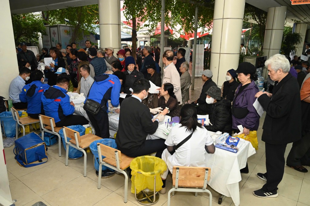 Các tình nguyện viên và cán bộ y tế tận tình hướng dẫn, hỗ trợ người cao tuổi trong suốt quá trình khám sức khỏe.