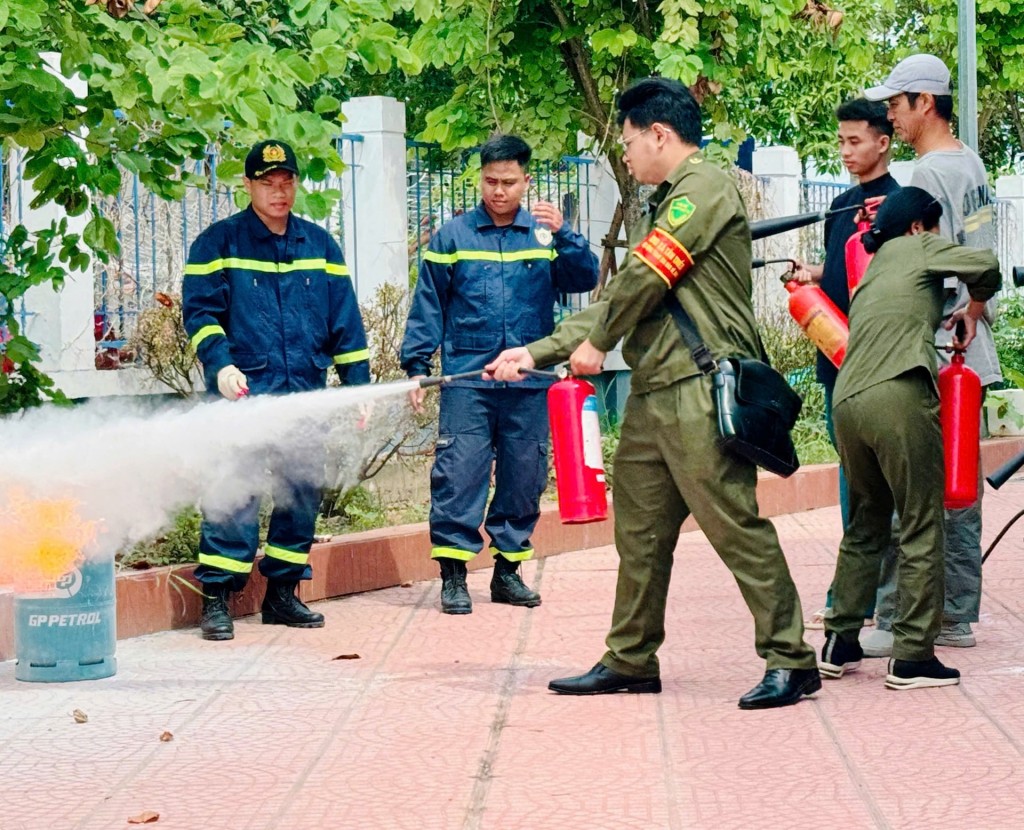 Lực lượng chức năng thành phố Hà Nội hướng dẫn người dân sử dụng thiết bị chữa cháy. Ảnh: Thu Xuyến