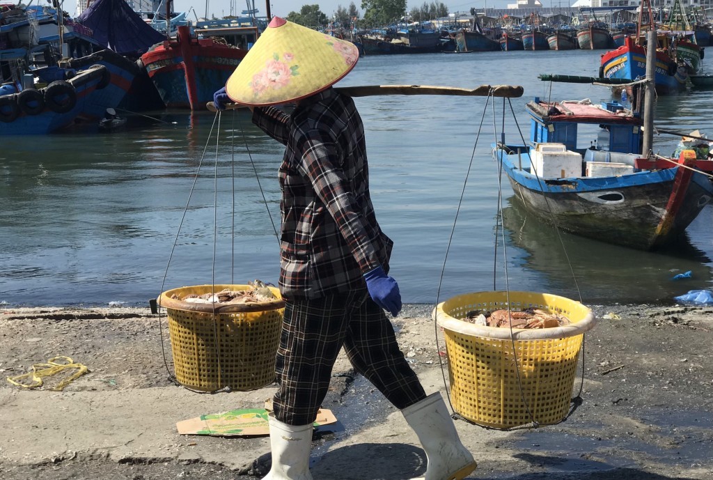 Ngư dân gánh hải sản từ trên tàu về bờ (Ảnh: Đ.Minh)