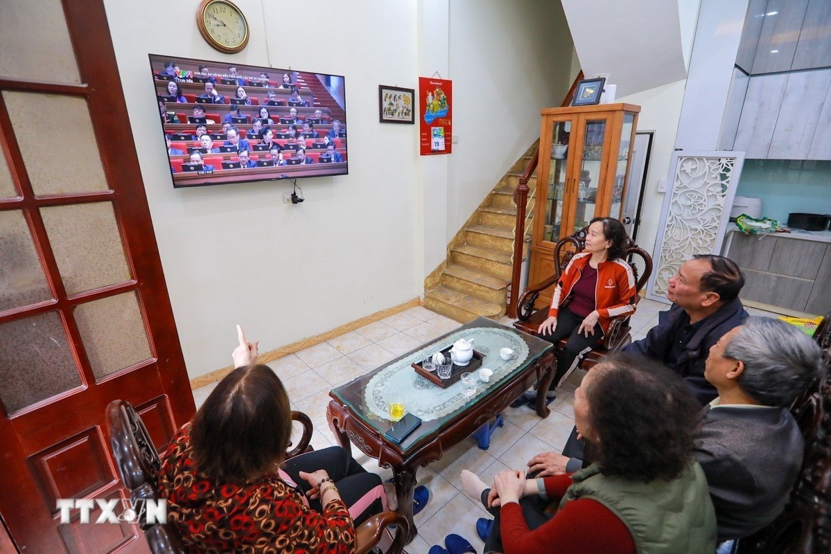 Nhân dân phường Bạch Mai (Hà Nội) theo dõi trực tiếp Lễ khai mạc trọng thể Đại hội XIV của Đảng Cộng sản Việt Nam. (Ảnh: TTXVN)