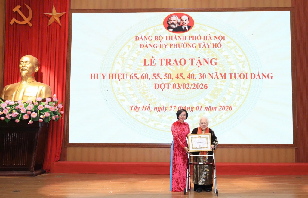 Đồng chí Bùi Huyền Mai - Ủy viên Ban Thường vụ Thành ủy, Chủ tịch Ủy ban Mặt trận Tổ quốc Việt Nam thành phố Hà Nội trao tặng Huy hiệu tới các đảng viên