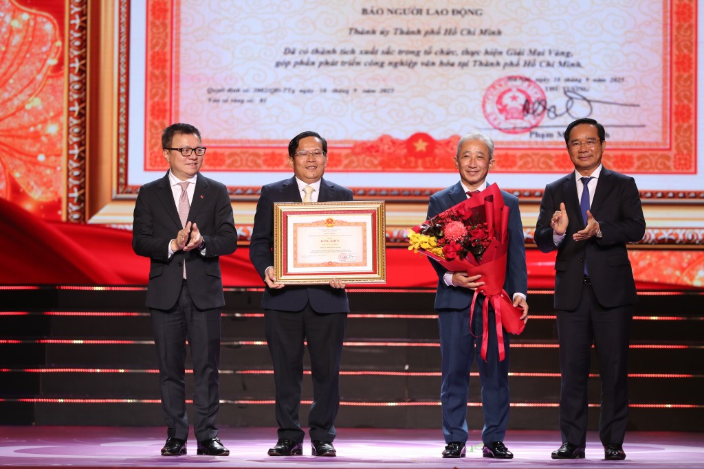 Ông Lê Quốc Minh - Ủy viên Trung ương Đảng, Phó trưởng Ban Tuyên giáo và Dân vận Trung ương, Chủ tịch Hội Nhà báo Việt Nam, Tổng Biên tập báo Nhân dân- và ông Nguyễn Văn Được - Ủy viên Trung ương Đảng, Phó Bí thư Thành ủy, Chủ tịch UBND TPHCM - trao bằng khen cho lãnh đạo Báo Người Lao Động