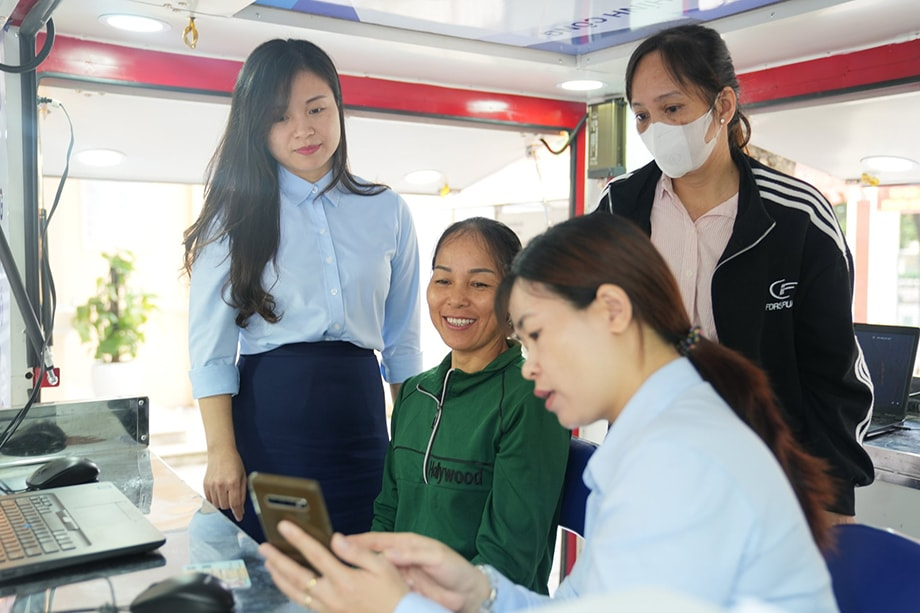 Người dân xã đảo Minh Châu (Hà Nội) được cán bộ Trung tâm Phục vụ hành chính công TP Hà Nội hướng dẫn làm thủ tục trên chiếc xe lưu động, một trong những hoạt động của mô hình “Dịch vụ công lưu động” Người dân xã đảo Minh Châu (Hà Nội) được cán bộ Trung tâm Phục vụ hành chính công TP Hà Nội hướng dẫn làm thủ tục trên chiếc xe lưu động, một trong những hoạt động của mô hình “Dịch vụ công lưu động”