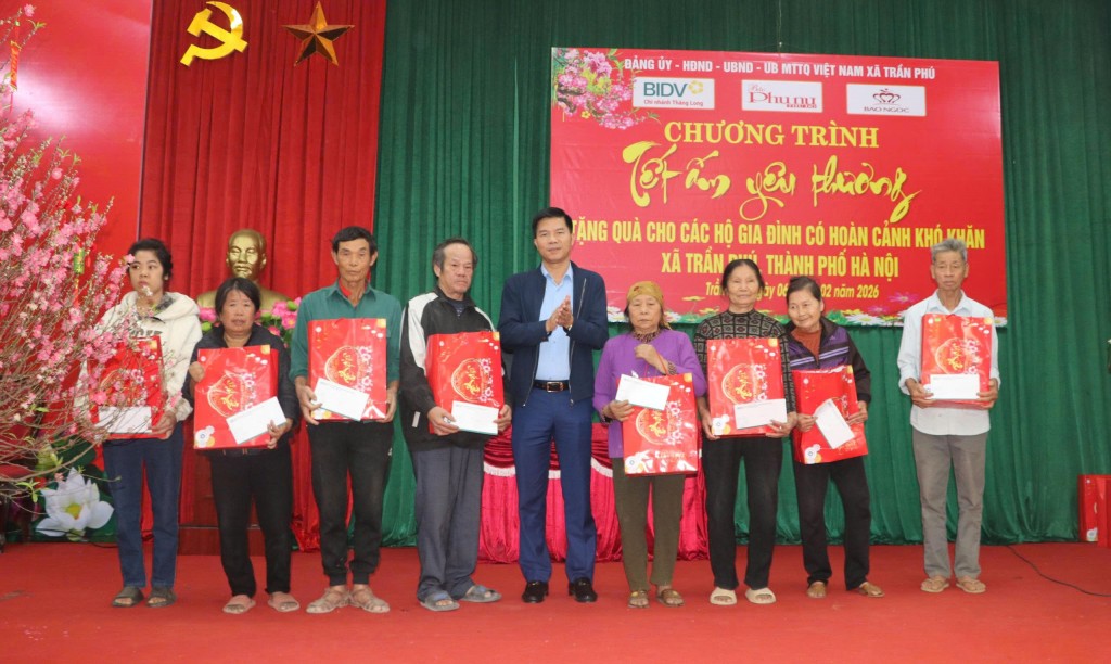 Ông Nguyễn Nguyễn Nguyên Hùng - Bí thư Đảng ủy xã Trần Phú trao quà tặng của Báo Phụ nữ Thủ đô và đơn vị tài trợ BIDV cho bà con