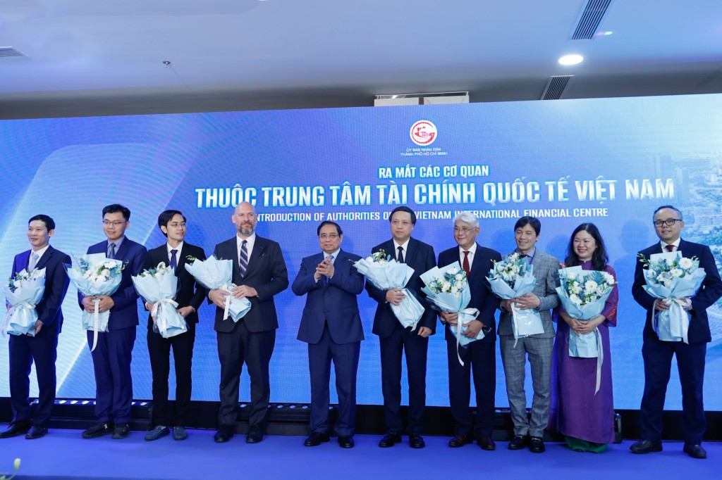 Thủ tướng Phạm Minh Chính tặng hoa cho đại diện các cơ quan thuộc Trung tâm Tài chính quốc tế Việt Nam - Ảnh: VGP/Nhật Bắc