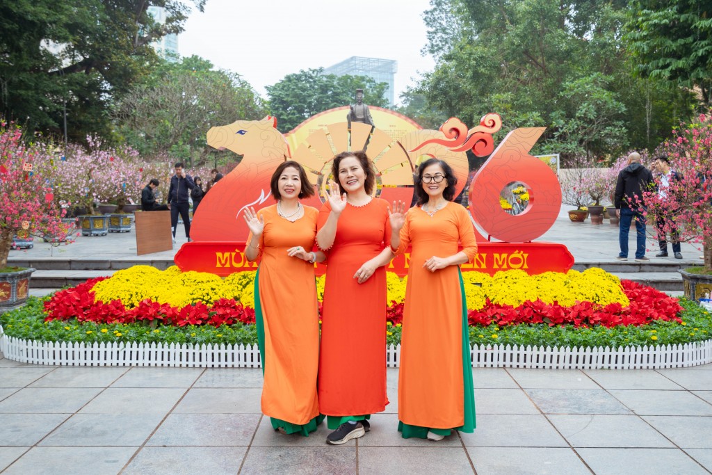 Những tà áo dài sặc sỡ màu sắc nổi bật hoà vào không gian hoa xuân.